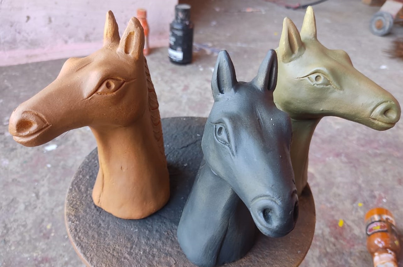 मिट्टी से निर्मित धोड़ों की मूर्तियाँ